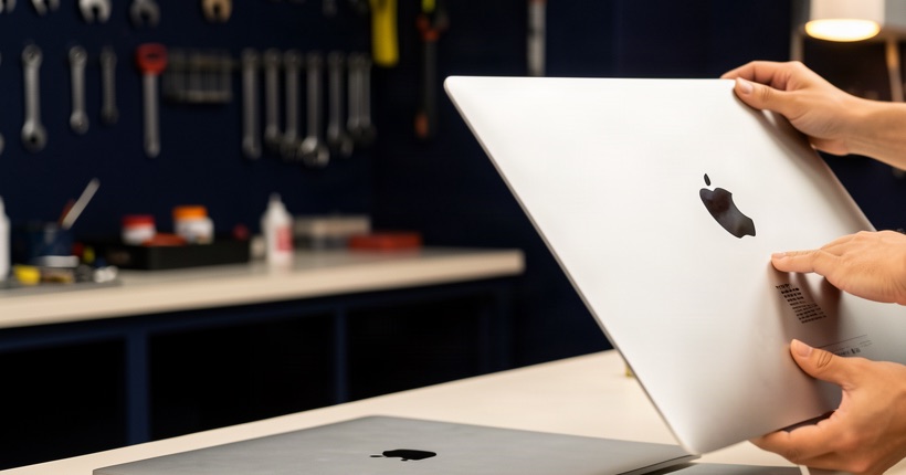 Repair technician pointing at the label on an iMac where the model number is printed